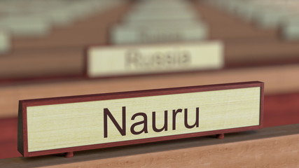 Nauru name sign among different countries plaques at international organization. 3D rendering