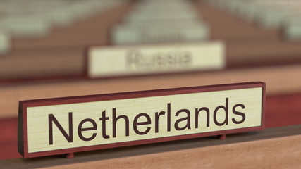 Fototapeta premium Netherlands name sign among different countries plaques at international organization. 3D rendering