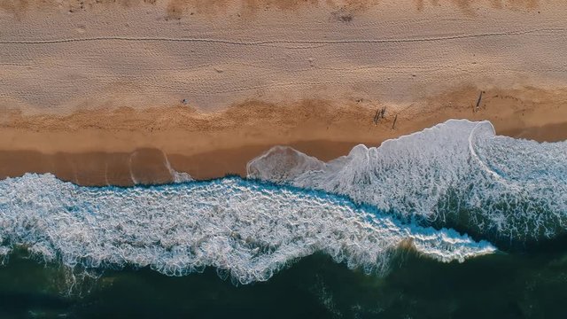 Aerial top shot of sandy golden beach waves and turquoise ocean. Perfect for wordpress website video background or nature travel video