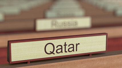 Qatar name sign among different countries plaques at international organization. 3D rendering