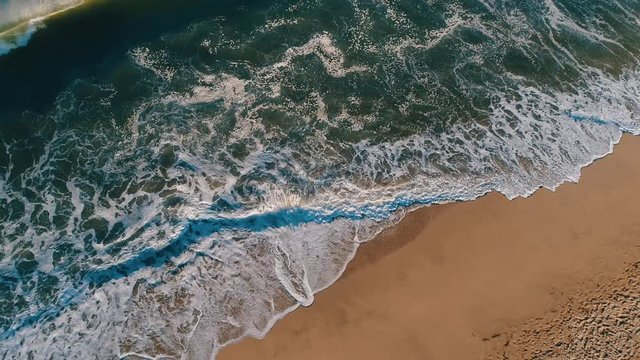 Aerial top shot of sandy golden beach waves and turquoise ocean. Perfect for wordpress website video background or nature travel video
