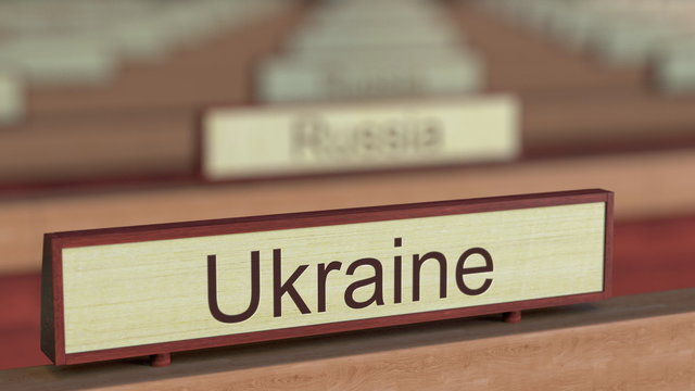 Ukraine name sign among different countries plaques at international organization. 3D rendering