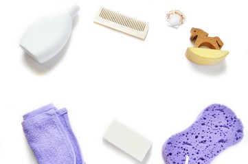 Flat lay bath products/ Shampoo, purple towel, comb, soap, wooden horse and sponge on a white background. Mockup, free space for text