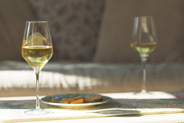 White wine glasses with a plate of cheese