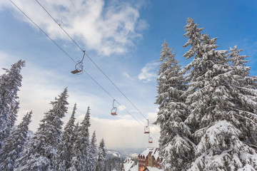 Ski lift with seats going over the mountain and paths from skies