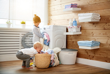 Fototapeta na wymiar Happy children boy and girl in laundry load washing machine.