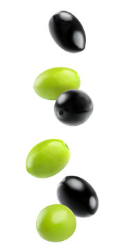 Isolated falling olives. Falling black and green olive fruits in the air isolated on white background with clipping path