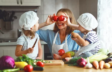 Poster Gezond eten. Gelukkige familie moeder en kinderen bereiden groentesalade. © JenkoAtaman
