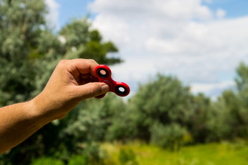 Man playing with fidget spinner stress relieving toy outdoor
