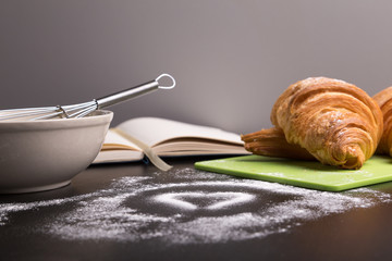 freshly baked croissants on green cutting board with flour