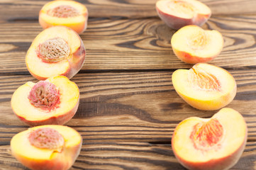 Two row of halves peaches with peach stone on rustic old wooden planks