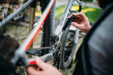 Verduisterende gordijnen Fietsen Handen met schroevendraaier reparatie shifter, fiets reparatie