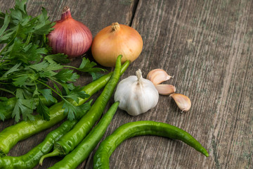 Onion, corn, garlic, pepper, coriander and parsley on an old wooden board