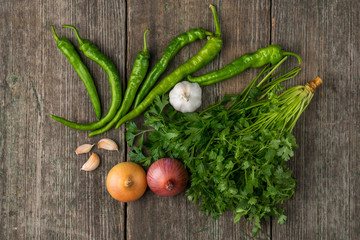 Onion, corn, garlic, pepper, coriander and parsley on an old wooden board