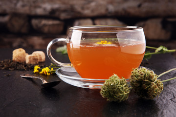 A cup of tea with tea leaves. Tea among the herbs.