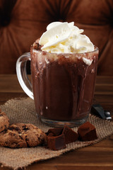 A messy cup with hot chocolate and chocolate chip cookies.