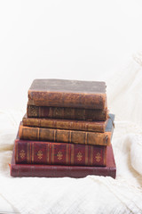 Pile of old aged books on romantic lace background