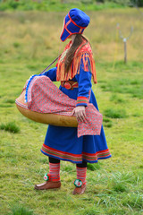 Northern Norway, a traditional dressed Sami woman with a cradle