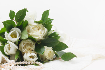 white fresh rose and tulips flowers with green leaves on white lace background