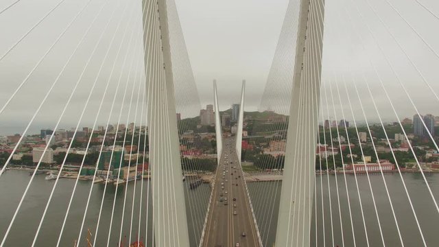 Amazing zooming out aerial view of the Zolotoy Bridge (the Golden Bridge) that is cable-stayed bridge across the Zolotoy Rog built in 2012 in Vladivostok, Russia, and cars driving on it. 4k