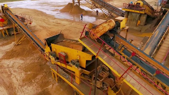 Sand moving on automatic conveyor belt. Mining conveyor sand sorting. Mining equipment at sand quarry. Mining machinery working at industrial area. Aerial view manufacturing line at mining sand
