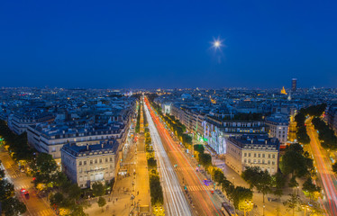 Fototapeta premium Moonrise over the Champs-Elysees in Paris at nightfall