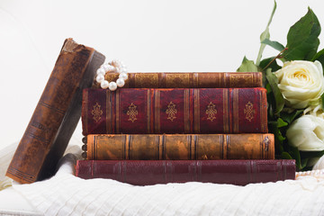 Old vintage books with white fresh flowers on romantic lace background