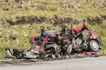 Unrecognizable car wreck beside a road