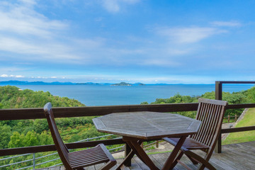 Fototapeta na wymiar Terrace chair and table of a hotel and Setonaikai (Seto Inland) Sea under blue sky in Ehime, Japan
