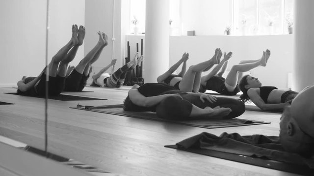 Group of people doing yoga asanas in studio
