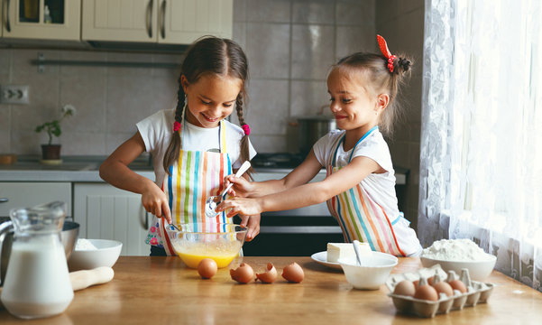 Happy family funny child sisrets twins bake kneading dough in kitchen