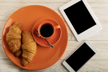 Coffee with milk, croissants, smartphone and e-book.