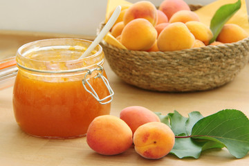 Apricot jam and fresh fruits on wooden table. Close up view.