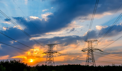 high-voltage power lines at sunset. electricity distribution station. high voltage electric...