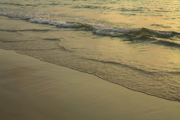 Soft wave surf on a sandy seaside beach.
