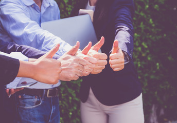 Close up at Group of businessman and woman thumbs up in front of office,success concept,dramatic filter tone