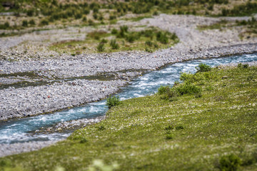 A small blue river flows in the mountainous country of Georgia.