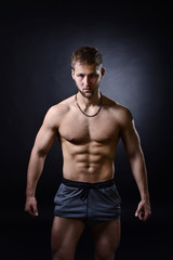 Fototapeta na wymiar Young bodybuilder on a black background