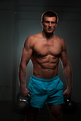 Fototapeta na wymiar Fitness man with shirtless body posing in gym