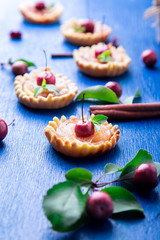 Apple caramel little tarts on blue rustic background. French tatin with paradise apple