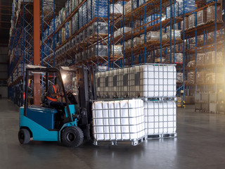 Containers for solvent are handling by forklift to storage in the warehouse and factory,plastic storage drum © Amarinj