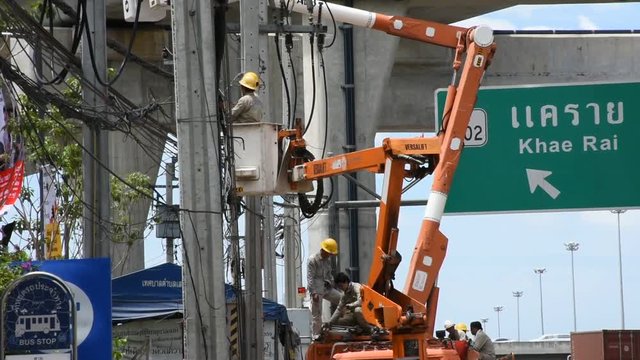 Electrician worker of Metropolitan Electricity Authority working repair electrical system on electricity pillar or Utility pole on August 9, 2017 in Nonthaburi, Thailand