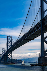 Oakland bay bridge with sailing boat underneath