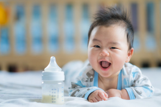 Asian Newborn baby smile with milk power bottle