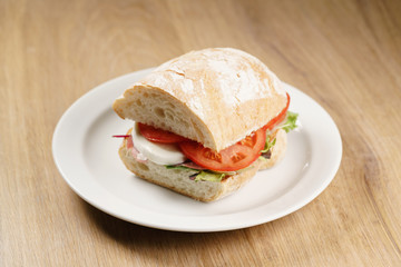 ciabatta sandwich with speck, mozzarella and vegetables