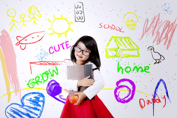 Cute child holds book and apple fruit