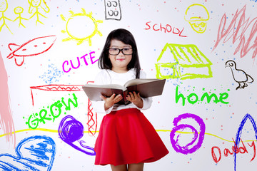 Cute child with book and colorful wall