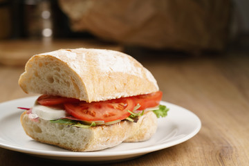 ciabatta sandwich with speck, mozzarella and vegetables