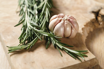 fresh rosemary bunch and garlic on wood table