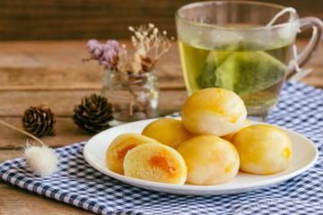 Chinese pastry with sweet mung bean and salted egg. Moon cake or Chinese pastry filled with mung bean paste and salted egg served with green tea. Delicious homemade Chinese pastry ready to served.